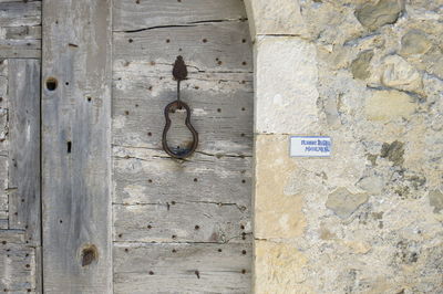 Close-up of hook hanging on wooden door