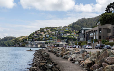 Houses by sea against sky in town