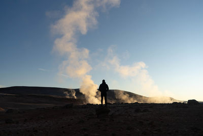 Silhouette man standing on field against sky