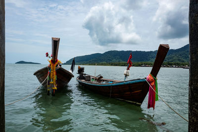 Boat moored on sea against sky