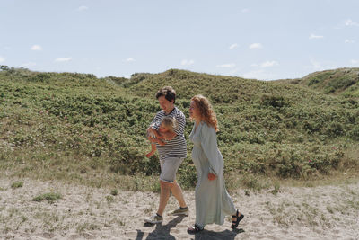 Rear view of family walking on field