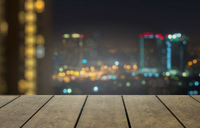 Defocused image of illuminated building against sky at night