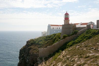 Buildings by sea against sky