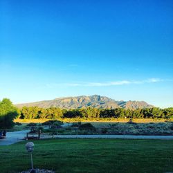 Scenic view of field against clear blue sky