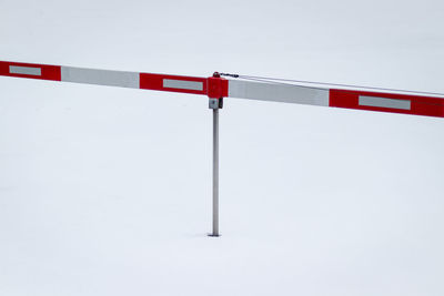 Road sign on snow covered landscape against sky