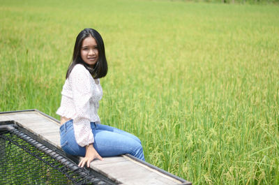 Portrait of young woman sitting on field