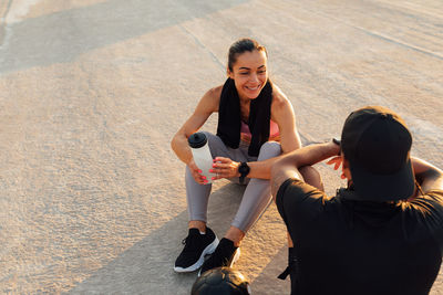 Side view of woman sitting on road