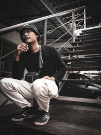 Young man sitting on staircase