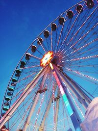 Low angle view of ferris wheel against clear blue sky