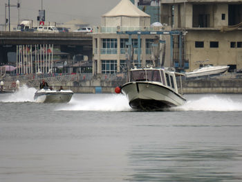 Boat in sea against buildings in city