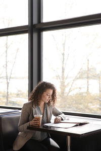 Businesswoman reading magazine at coffee shop