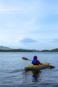 Woman kayaking. rear view of a young woman splashing water while kayaking on river person