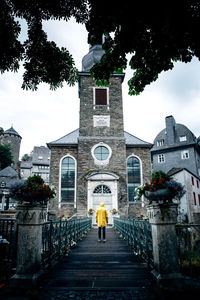 Rear view of woman amidst buildings against sky