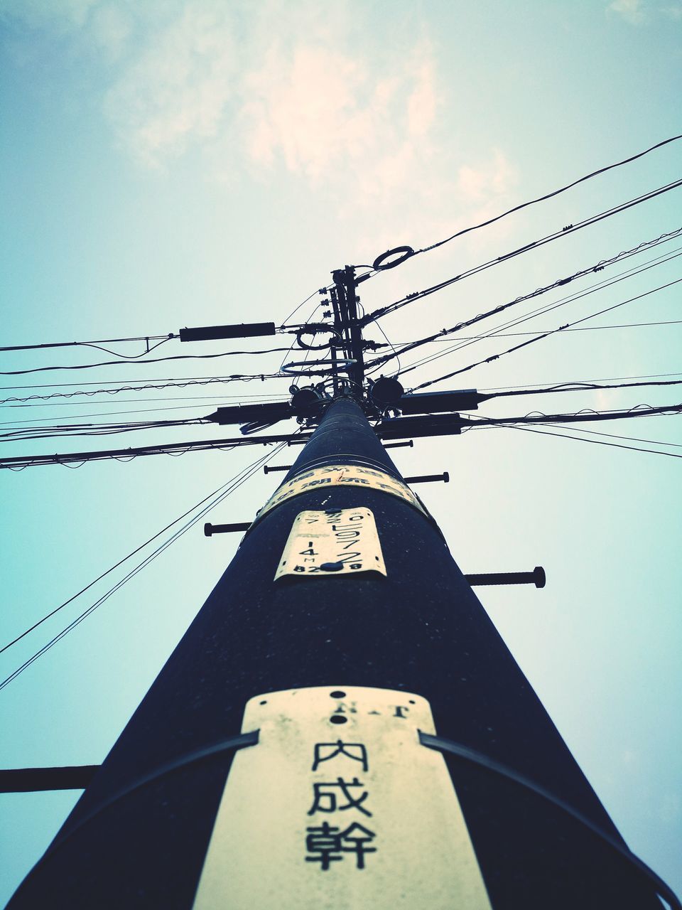 CLOSE-UP LOW ANGLE VIEW OF TELEPHONE POLE AGAINST SKY