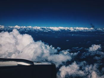 Scenic view of airplane wing against blue sky