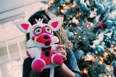 Close-up of girl holding christmas present against face