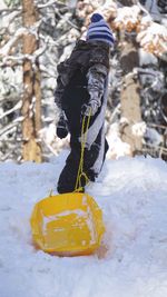 Person with tobaggan in snow