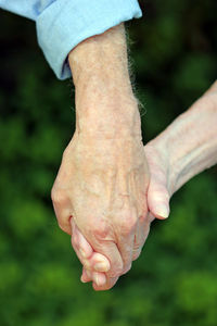 Cropped image of senior couple holding hands