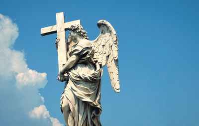 Low angle view of statue against blue sky