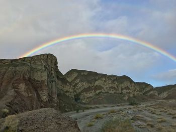 Scenic view of rainbow over mountain against sky