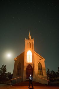 Low angle view of illuminated building against sky at night