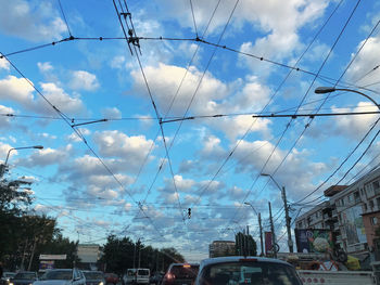 Cars on street in city against sky