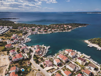 High angle view of townscape by sea against sky