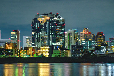 Illuminated buildings against sky at night