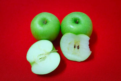 Close-up of apples on table against red background