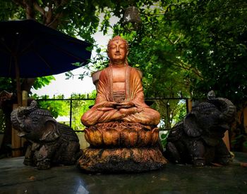 Statue against trees and plants