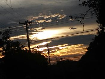 Silhouette of electricity pylon at sunset