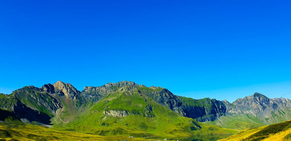 Scenic view of mountains against clear blue sky