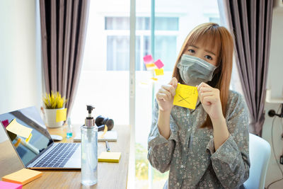 Portrait of woman using mobile phone at home