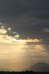 Low angle view of silhouette mountain against dramatic sky