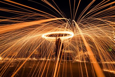 Man spinning wire wool at night