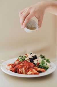 Close-up of person preparing food in plate