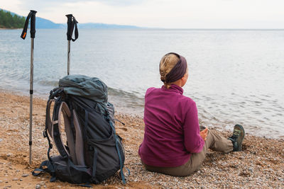 Rear view of woman sitting on beach