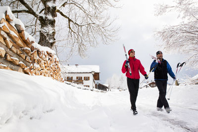 Two men walking with skis