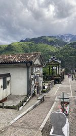 Houses by road in town against sky