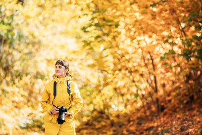 Full length of woman standing against trees