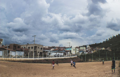 People playing soccer against sky