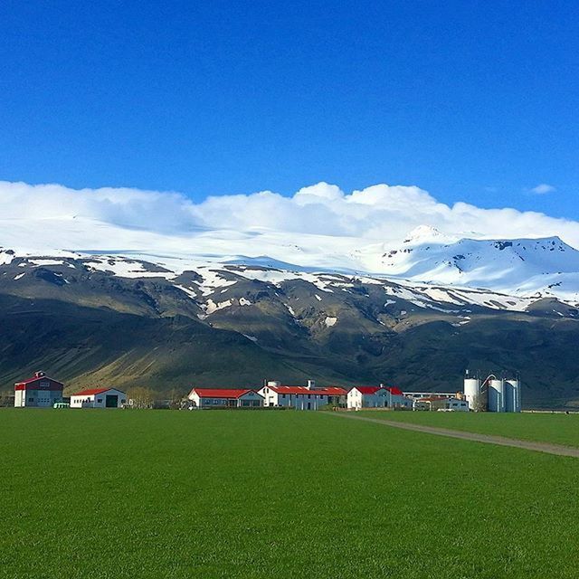 mountain, landscape, mountain range, tranquil scene, sky, scenics, tranquility, beauty in nature, blue, field, nature, grass, house, snowcapped mountain, cloud - sky, non-urban scene, winter, cloud, rural scene, green color