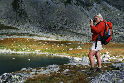 Woman standing on rock by river