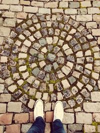 Low section of woman standing on cobblestone