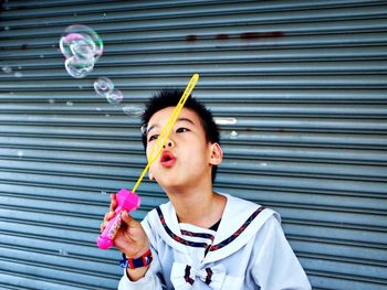 Close-up of cute boy playing with bubble wand