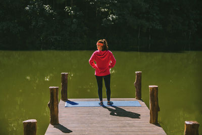 Full length of woman standing on pier over lake