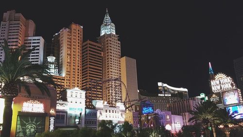 Low angle view of illuminated buildings against sky at night