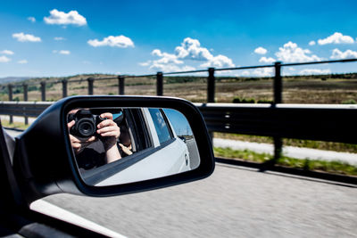 Reflection of man in side-view mirror