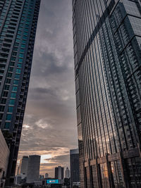 Low angle view of modern towers with sunset