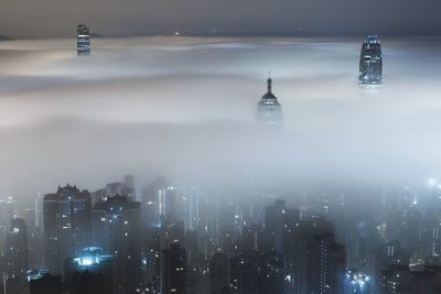 Modern buildings amidst fog at night